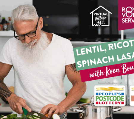a man with a beard and glasses in a white t-shirt slicing courgette in a kitchen